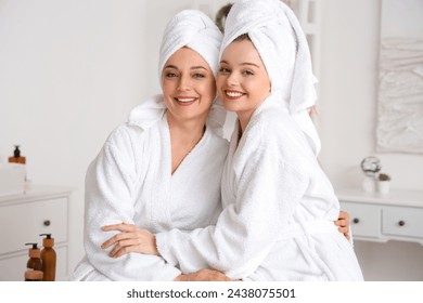 Young woman with her mother after shower hugging in bathroom - Powered by Shutterstock