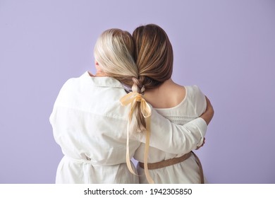 Young Woman And Her Mother With Braided Together Hair On Color Background, Back View