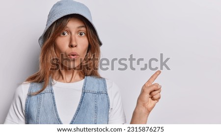 Young woman with her mouth agape and finger pointing to side she exudes surprise and wonder making viewer curious about unexpected sight that caught her attention shows place for your advertisement
