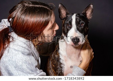 young woman with her pet in confinement, bull terrier bitch