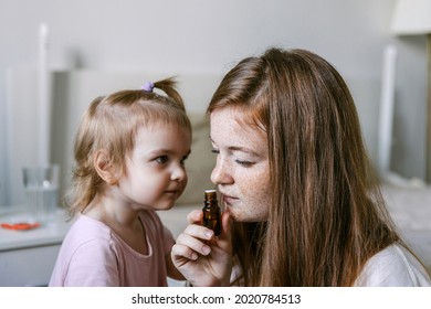 Young Woman And Her Two Year Old Daughter Are Sniffing Essential Oil. Loss Of Smell And Taste From Covid