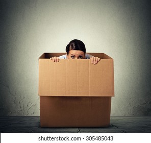 Young woman hiding in a carton box