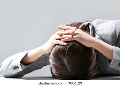 A Young Woman Hiding Her Face On Table