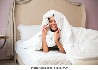 Young Woman Hiding Under Blanket. Lady Smiling And Looking Aside. Let's Play Hide And Seek.