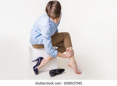 Young woman in high heels massaging her tired legs. Varicose veins concept. Painful varicose and spider veins on female legs. Phlebology 