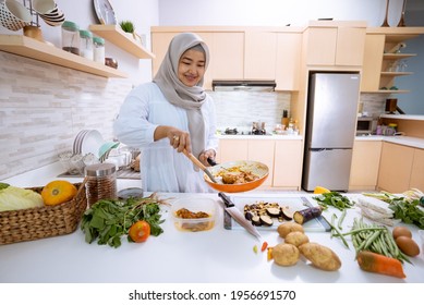 Young Woman With Hijab Cooking In Her House With Modern Kitchen For Dinner