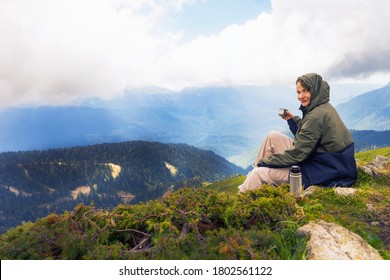 Junge Wanderer trinken Kaffee oder Tee in schönen Bergen auf Wanderung. Aktive Person, die sich in der Natur ausruht. Female Rucksackpacker-Campingplatz außerhalb der Freizeit aktiv