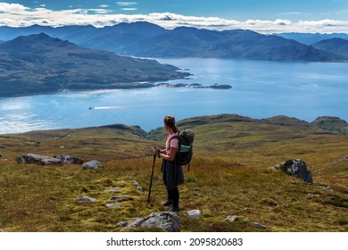 Young woman hiking and gazing at the landscape of Isle of Skye, Scotland, United Kingdom