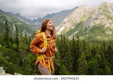 Young woman  hiking girl with backpacks. Hiking in nature. Sunny landscape. A young traveler travels along mountain paths. Adventure, travel concept. - Powered by Shutterstock