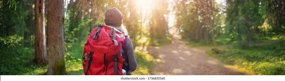 Young woman hiking and going camping in nature. Person with backpack walking in the forest