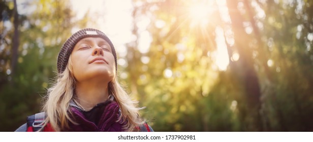 Young woman hiking and going camping in nature. Person with backpack walking in the forest