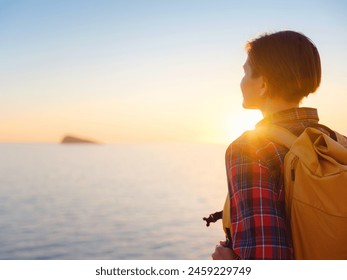 Young woman hiking on rocky beach in Spain, Benidorm. Watching the choppy sea and the bay. traveler enjoying freedom in serene nature landscape - Powered by Shutterstock