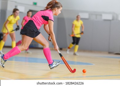 Young Woman Hockey Player In Attack At Indoor Hockey Match