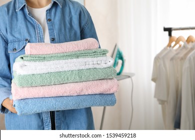 Young woman hold clean towels, close up and space for text