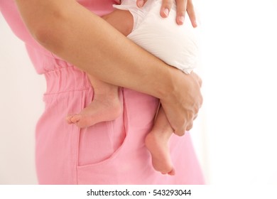 Young woman holding baby on light background, close up view - Shutterstock ID 543293044