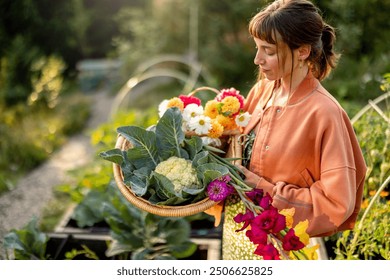 A young woman holding a basket filled with freshly harvested vegetables and vibrant flowers in a sunlit garden. A moment capturing the essence of sustainable living and natural beauty - Powered by Shutterstock