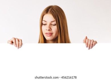 Young Woman Holding A Big Billboard, Looking Down On It.