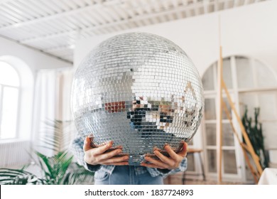 Young Woman Holding Big Disco Ball In Hands.