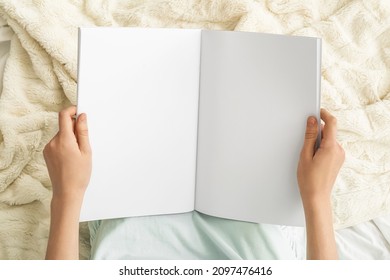 Young Woman Holding Blank Magazine On Light Background