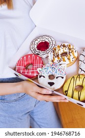 Young Woman Holding Box Of Delicious Donuts. Party Concept. No Diet. Candy Bar. Proper Nutrition Or Sweets, Dessert Fast Food. Unhealthy Lifestyle Concept. Doughnuts From Food Delivery.