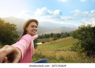 Young woman holding boyfriend's hand in mountains, space for text - Shutterstock ID 2071743629
