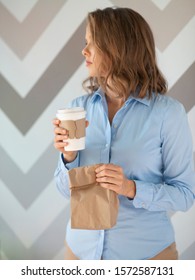 Young Woman Holding Brown Paper Bag With Meal For Lunch And Cup Of Coffee