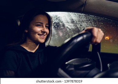 Young Woman Holding A Car Driving Wheel In A Rainy Night Rain Smiling