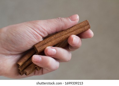 Young Woman Holding Cinnamon Sticks In Her Hand