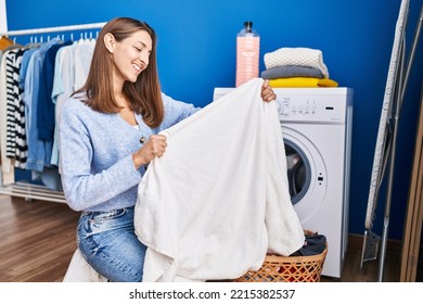 Young Woman Holding Clean Towel Washing Clothes At Laundry Room