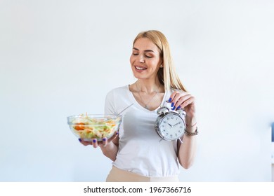 Young Woman Holding Clock And Healthy Food Of Salad Intermittent Fasting Concept. Time To Lose Weight , Eating Control Or Time To Diet Concept.