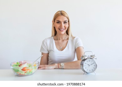 Young Woman Holding Clock And Healthy Food Of Salad Intermittent Fasting Concept. Time To Lose Weight , Eating Control Or Time To Diet Concept.