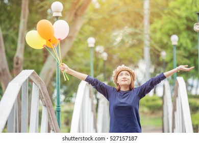 young woman holding  colorful balloons in the garden