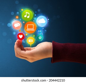 Young woman holding colorful multimedia icons in her hand - Shutterstock ID 204442210