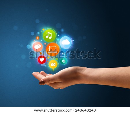Young woman holding colorful multimedia icons in her hand