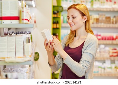 Young Woman Holding Cosmetics In Her Hand In Drugstore Department Of A Supermarket