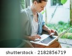 Young woman holding credit card shopping online using laptop at home