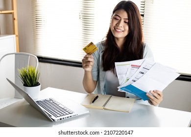 Young woman holding credit card and bill with smile happily after no debt. Not worried about the problems caused by credit card debt. - Shutterstock ID 2107220147
