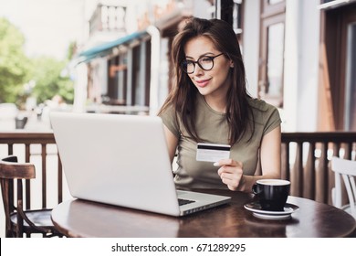 Young Woman Holding Credit Card And Using Laptop Computer. Online Shopping Concept