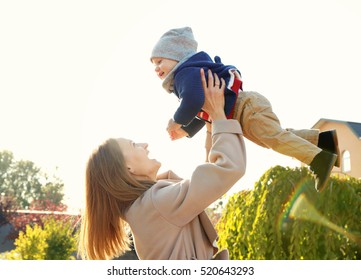 Young Woman Holding Cute Little Baby Outdoors