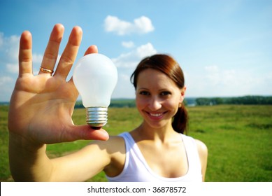 Young woman holding  electric bulb in hand.