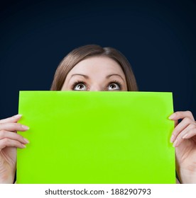 Young woman holding an empty billboard over black background - Powered by Shutterstock