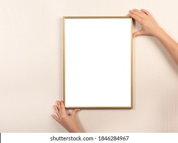 Young Woman Holding Empty Picture Frame With Copyspace In Vertical Position. Hanging A Photo Frame Mockup On A White Wall. Picture Frame Mockup