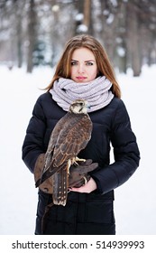 Young woman holding a falcon on arm