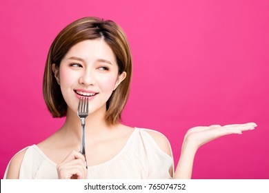 Young Woman Holding Fork And Showing Tasty Food 
