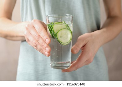 Young Woman Holding Glass With Fresh Cucumber Water, Closeup