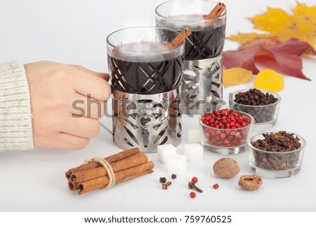Young Woman holding glass of hot mulled wine. Homemade hot spicy wine.