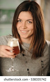 Young Woman Holding Glass Of Red Beer