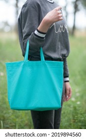 Young Woman Holding Green Tote Bag, No Face