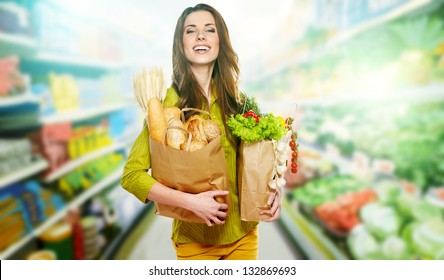 Young Woman Holding A Grocery Bag Full Of Bread