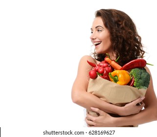 Young woman holding grocery paper shopping bag full of fresh vegetables. Diet healthy eating concept isolated on a white background